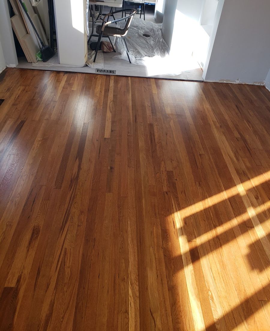The same oak floor after SURFS sanded and refinished it, with an even sheen