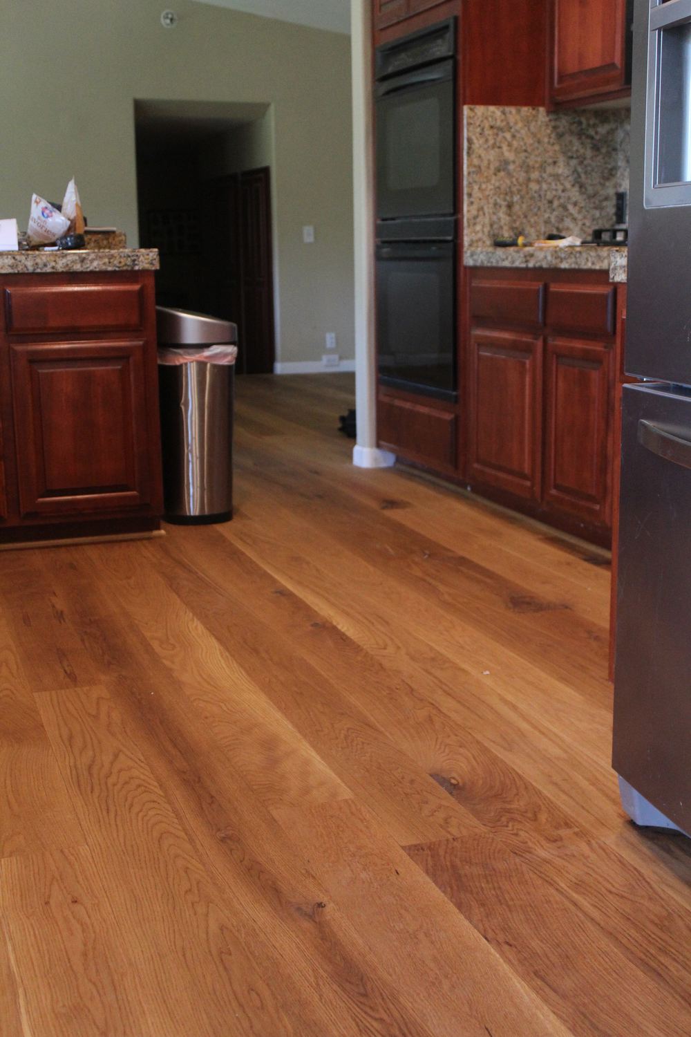 Refinished oak floor running through a kitchen