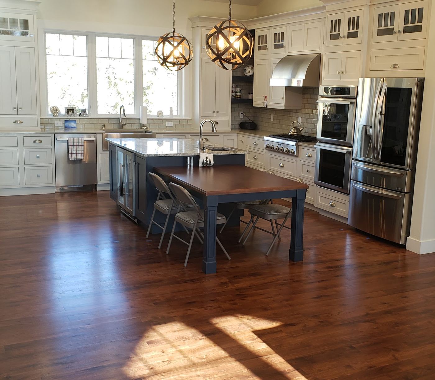 Refinished dark hardwood floor in a bright open kitchen